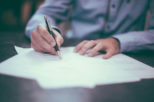 A person completes a form at a desk.